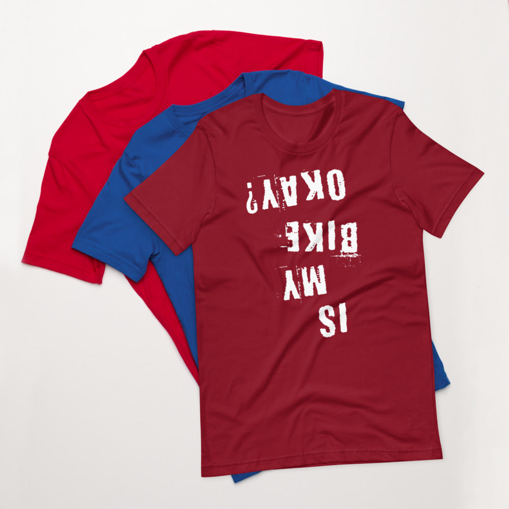 Three cotton t-shirts—red, blue, and maroon. Maroon shirt features distressed white upside-down “Is My Bike Okay?” cycling graphic.