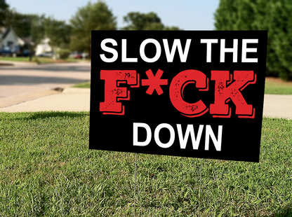 InkBird Print Studio 18x24 vinyl Slow The F*ck Down (censored) yard sign, bold black/red text on white, metal stake in grass curbside.