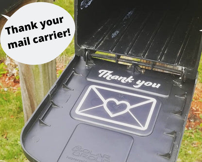 Vinyl “Thank your mail carrier!” decal features a white envelope with a red heart; adhesive, mailbox-ready, fits standard mailbox lid.